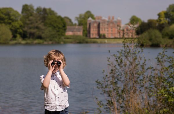 Child looking through bonoculars at Kiplin Hall Gardens