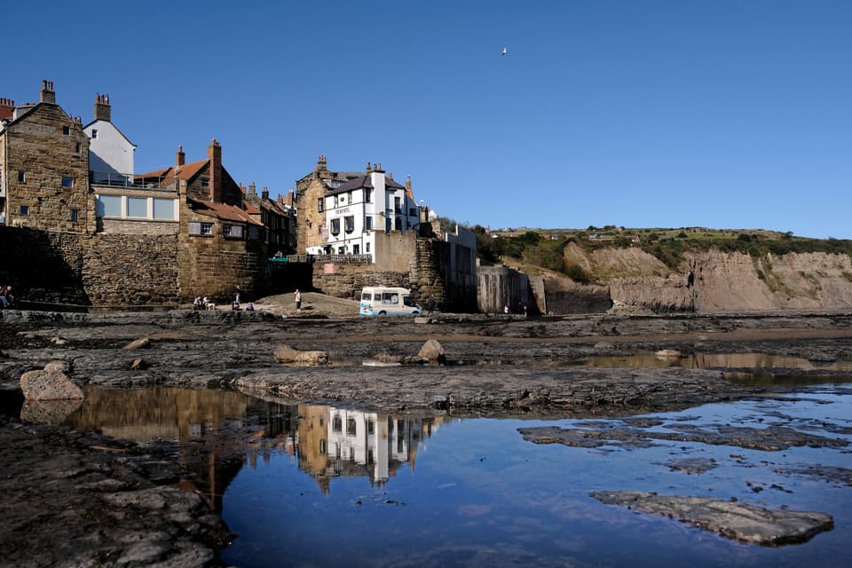 Robin hoods bay with The Bay Hotel reflected on the water